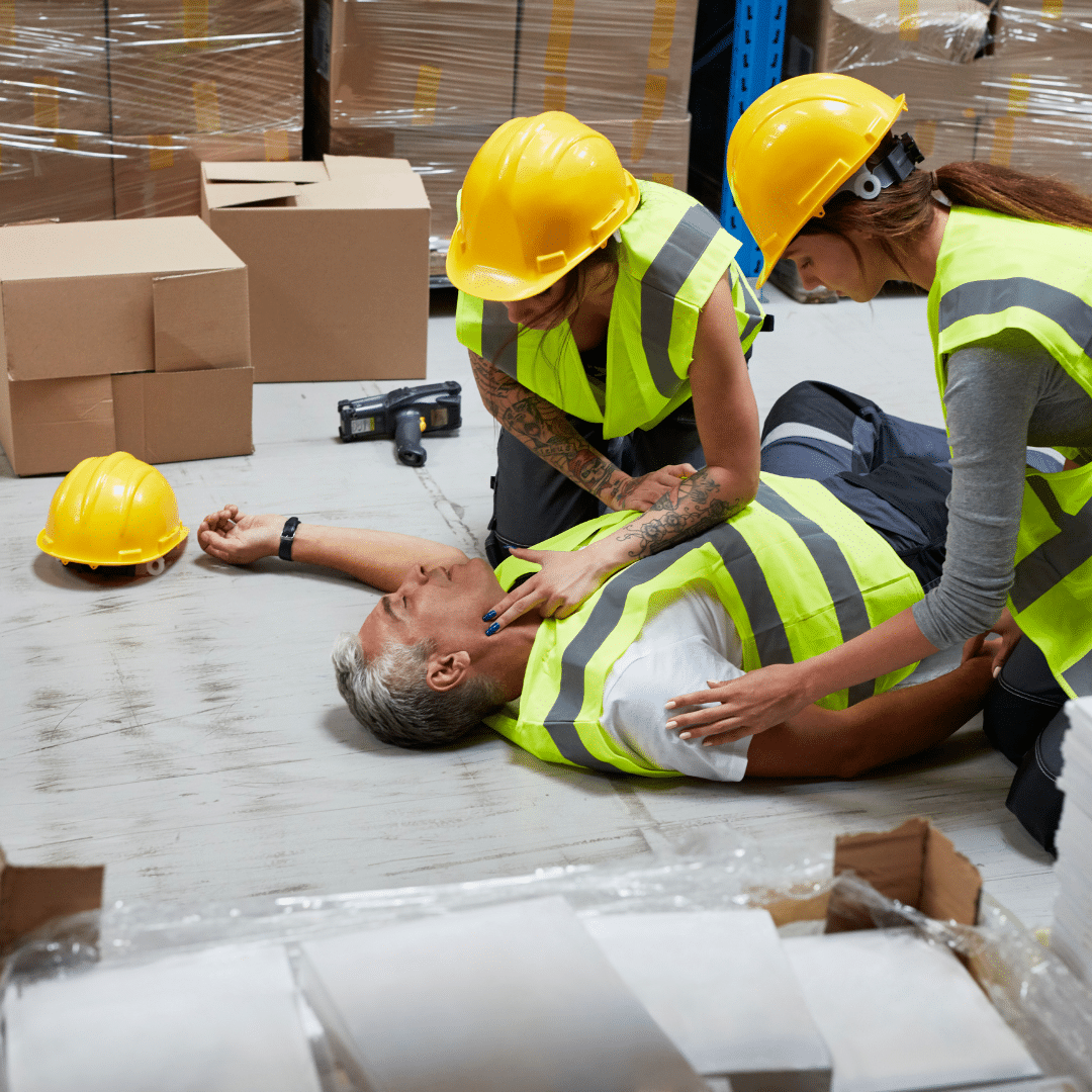 Two workers checking the pulse of a coworker who passed out